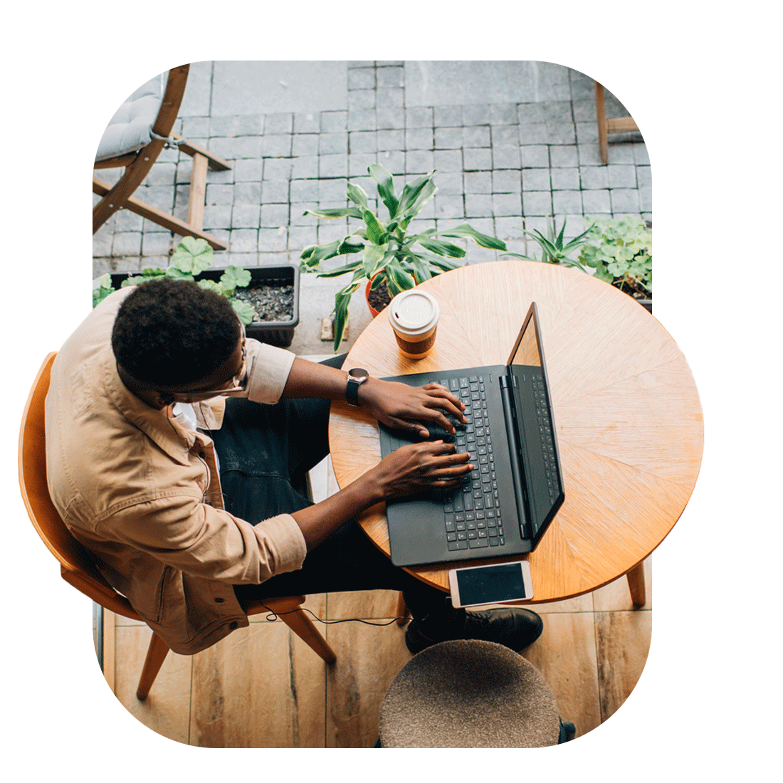 A man seated at a table with a laptop, showcasing the advanced security features of Connect & Protect for WiFi networks.