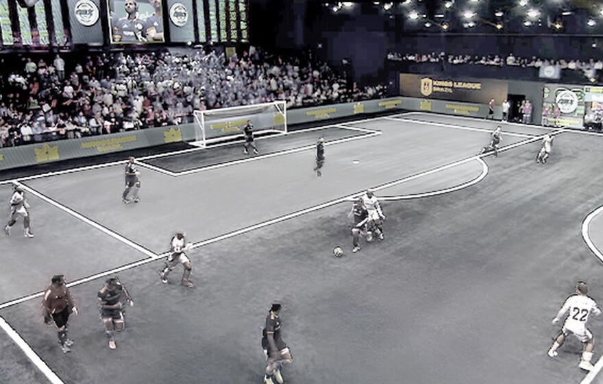 Players compete in a fast-paced Kings League Brazil match as spectators watch and digital screens enhance the immersive indoor arena experience.
