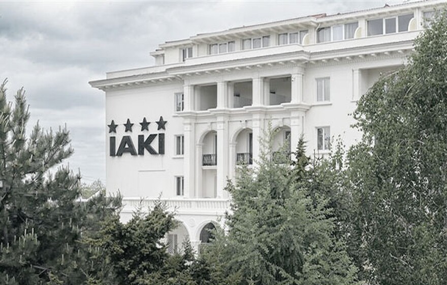IAKI Conference & Spa Hotel exterior view with classic architecture and four-star sign, surrounded by lush green trees in Mamaia.