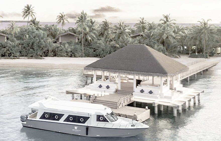 A white boat docked at a wooden pier leading to the JW Marriott Maldives Resort & Spa pavilion.