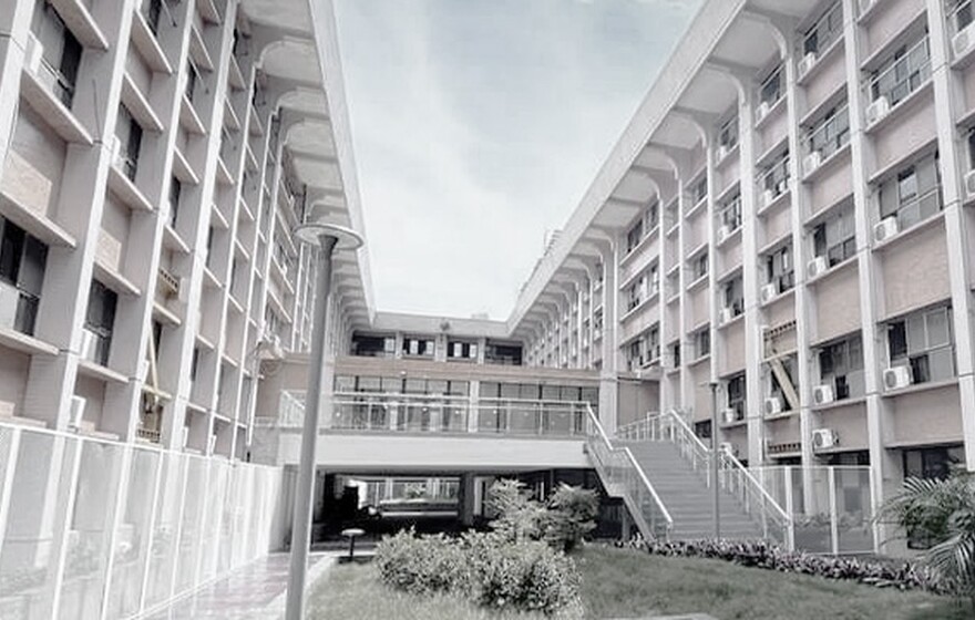 Providence University academic building featuring a modern sky bridge and lush greenery under a bright, clear blue sky.