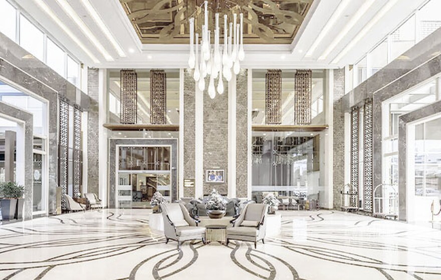 Case study: A modern Indian hotel lobby with seating areas, a marble reception desk, high ceilings, and hanging lights
