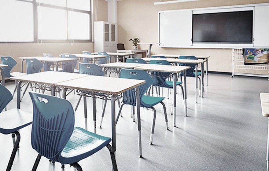 Modern classroom with blue chairs and desks, large screen, sunlight, and a smart setup, bringing seamless WiFi and network management to city education offices.