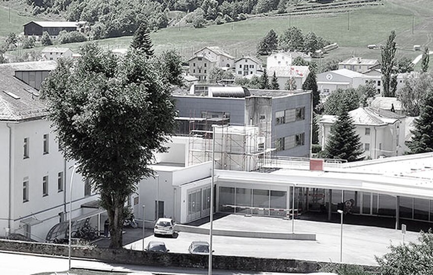 Valposchiavo Health Center in Switzerland surrounded by greenery, showcasing its multi-building healthcare facility.
