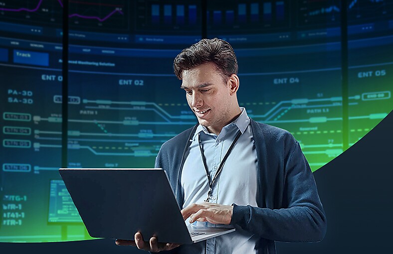 A suited man is operating a laptop appearing concentrated on his work.