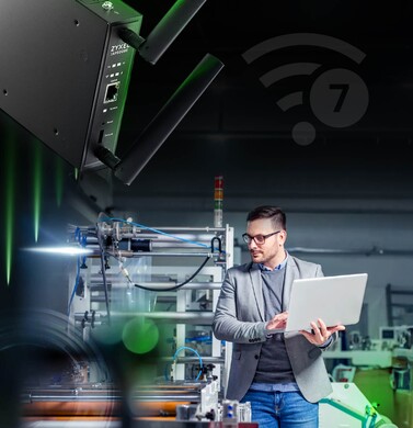 A man operates a laptop in a factory, representing Zyxel's commitment to enhancing industrial automation showcased at FITAG.