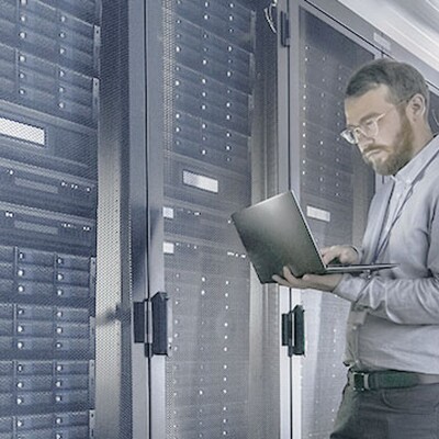 An IT professional uses a laptop to manage network servers, representing Zyxel's Nebula secure cloud management case study