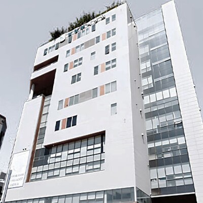 A tall, modern white hospital building with orange accents and large glass windows under a clear blue sky in Namyangju.