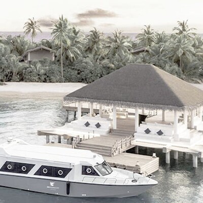 A white boat docked at a wooden pier leading to the JW Marriott Maldives Resort & Spa pavilion.