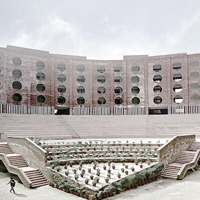 Modern red-brick university building with circular windows, large open amphitheater steps, landscaped courtyard, and students walking around.