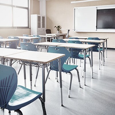 Modern classroom with blue chairs and desks, large screen, sunlight, and a smart setup, bringing seamless WiFi and network management to city education offices.