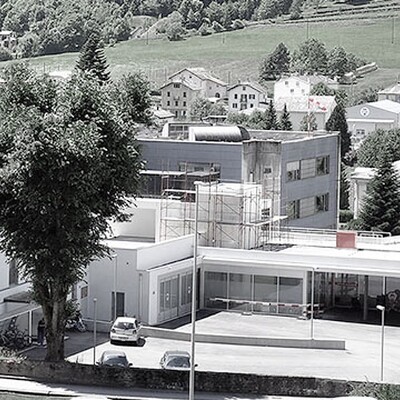 Valposchiavo Health Center in Switzerland surrounded by greenery, showcasing its multi-building healthcare facility.