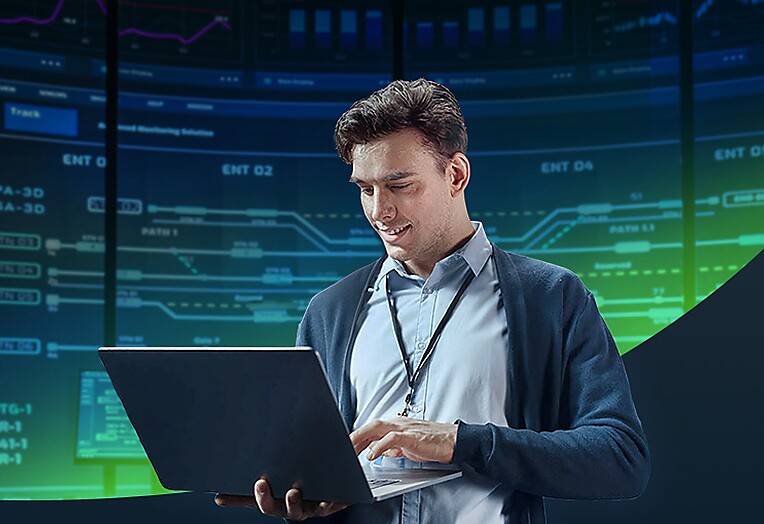 A suited man is operating a laptop appearing concentrated on his work.