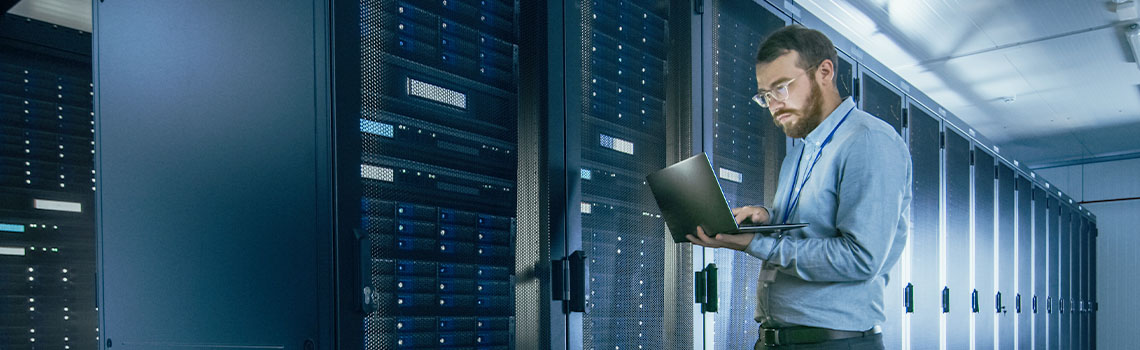 An IT professional uses a laptop to manage network servers, representing Zyxel's Nebula secure cloud management case study
