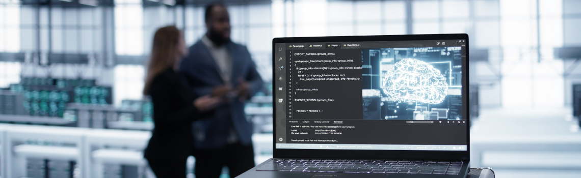 Laptop in a data center displaying code and a glowing digital brain icon with two blurred figures in the background.