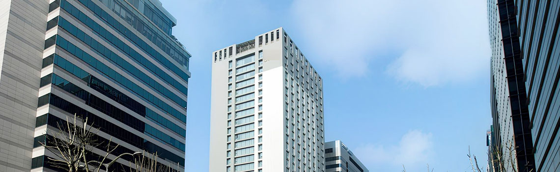 Zyxel Nebula case study. Korean hotel in an urban area with a row of tall modern glass and concrete high-rise buildings. 