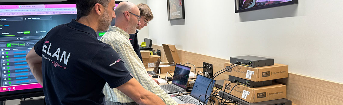 Nebula MSP Pack case study. IT staff configure Zyxel Ethernet switches and laptops in a workspace with monitoring screens.
