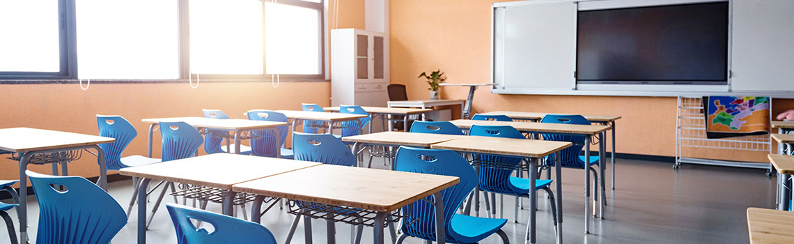Modern classroom with blue chairs and desks, large screen, sunlight, and a smart setup, bringing seamless WiFi and network management to city education offices.